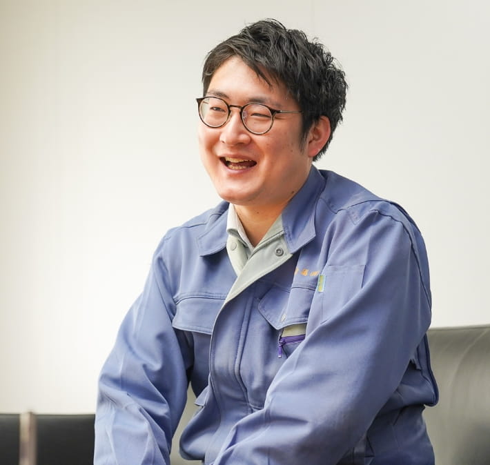 作業服を着た男性が生き生きとした表情で話している
