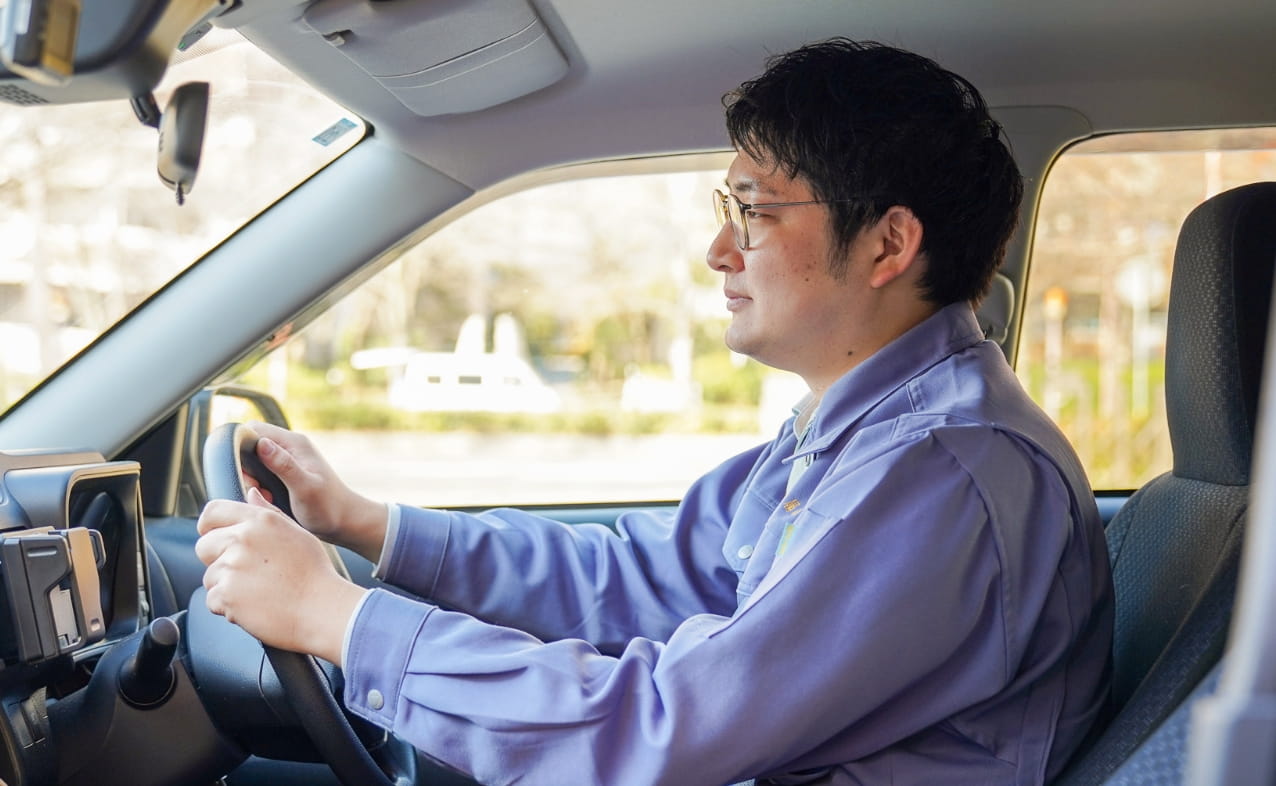 男性が営業先に車で向かっている様子