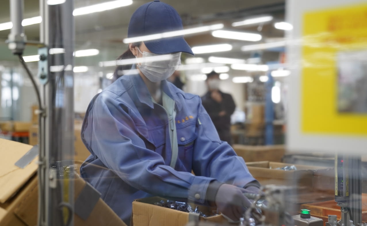 女性がデスクでパソコンを操作し、業務に集中している。