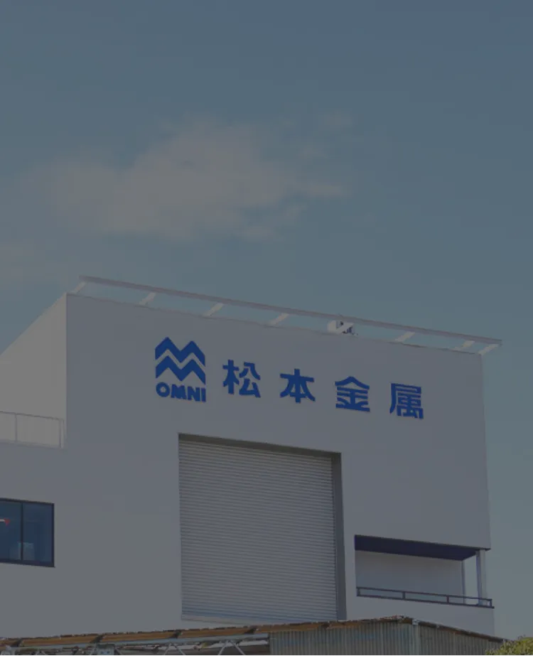 白い建物の壁に会社名とロゴが描かれており、企業の存在感を示している